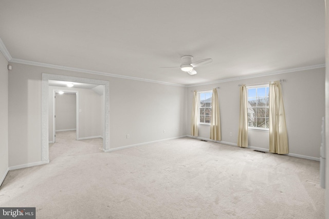 spare room with ornamental molding, light colored carpet, and ceiling fan