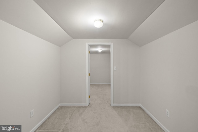 additional living space featuring lofted ceiling and light carpet