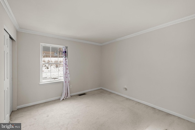 carpeted spare room featuring ornamental molding