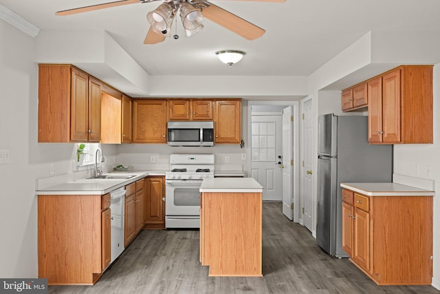 kitchen featuring stainless steel appliances, a center island, sink, and light wood-type flooring