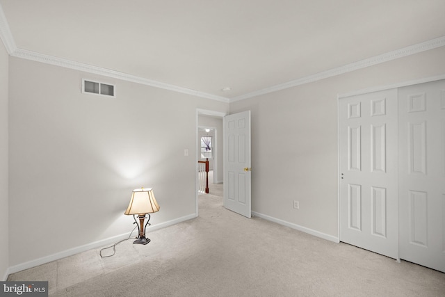 empty room featuring crown molding and light carpet