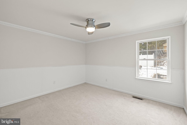 spare room featuring carpet floors, ornamental molding, and ceiling fan