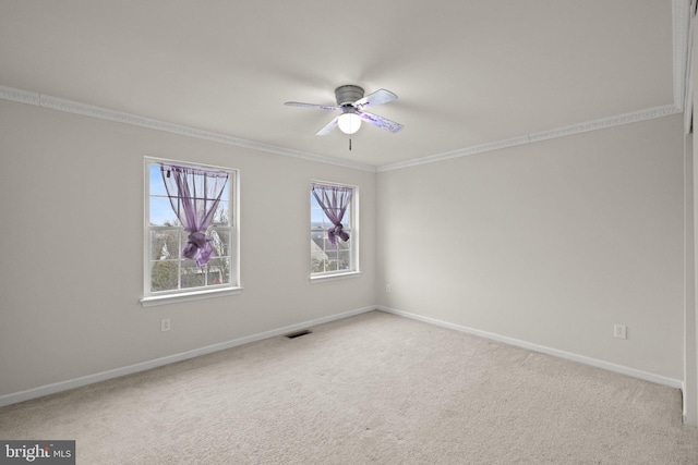 spare room featuring light carpet, crown molding, and ceiling fan