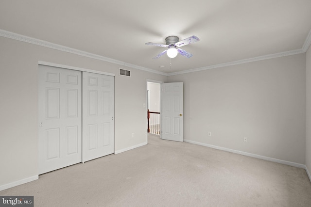 unfurnished bedroom featuring ornamental molding, light colored carpet, a closet, and ceiling fan