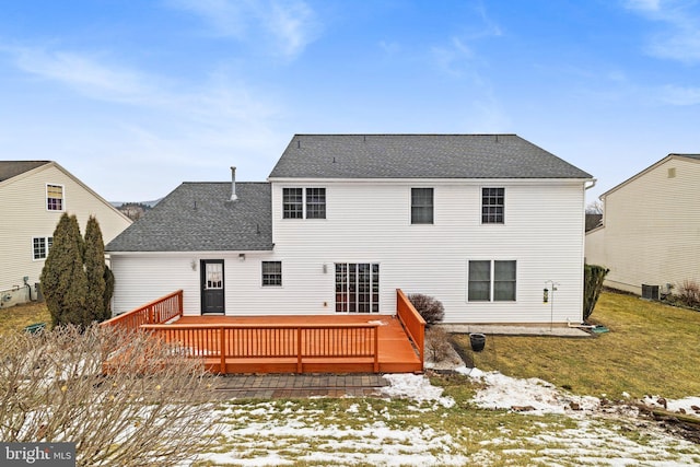 snow covered back of property featuring a wooden deck, central AC, and a lawn