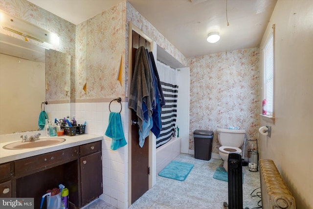 full bathroom featuring radiator, tile walls, vanity, shower / bath combination with curtain, and toilet