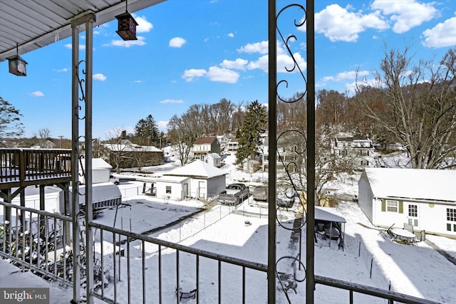 view of snow covered back of property