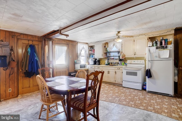 dining area featuring wooden walls and ceiling fan