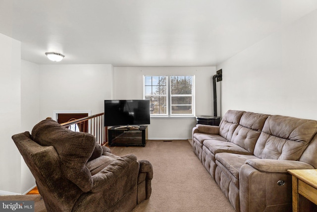 living room with a wood stove and light carpet