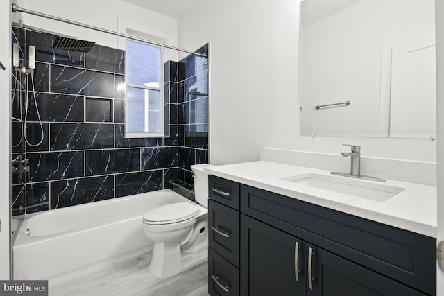 full bathroom with tiled shower / bath, vanity, and toilet