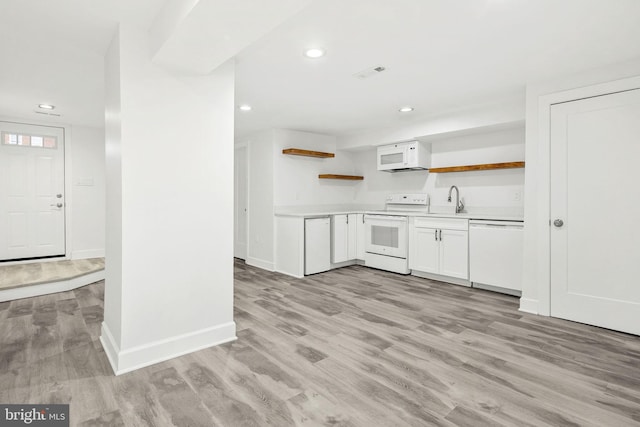 kitchen featuring white appliances, light wood-type flooring, and white cabinets