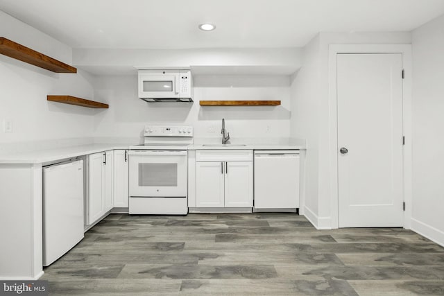 kitchen featuring dark hardwood / wood-style flooring, sink, white cabinets, and white appliances