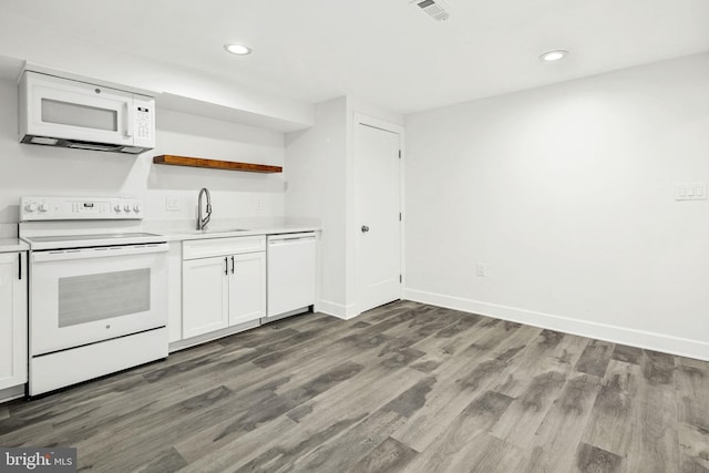 kitchen with sink, white appliances, hardwood / wood-style floors, and white cabinets