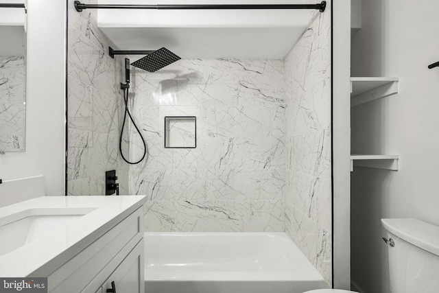 full bathroom featuring tiled shower / bath, vanity, and toilet