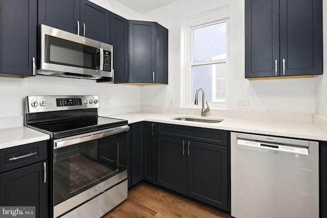 kitchen featuring appliances with stainless steel finishes, sink, and hardwood / wood-style floors