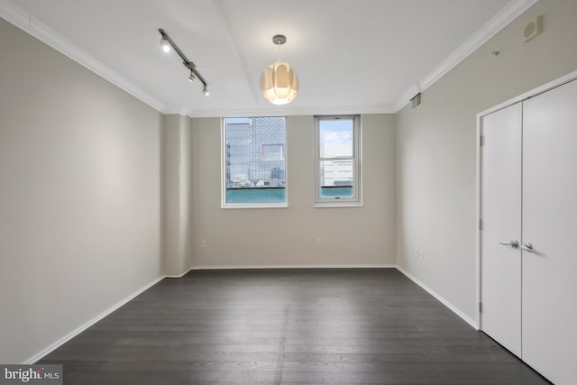 interior space with dark hardwood / wood-style flooring, crown molding, and rail lighting