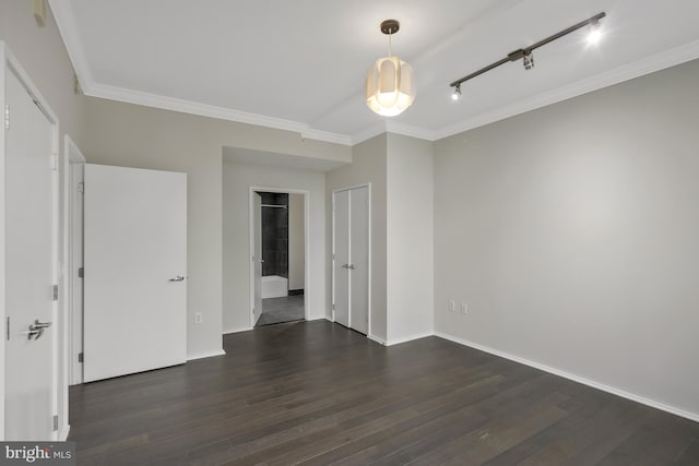 unfurnished bedroom with rail lighting, ornamental molding, and dark hardwood / wood-style floors