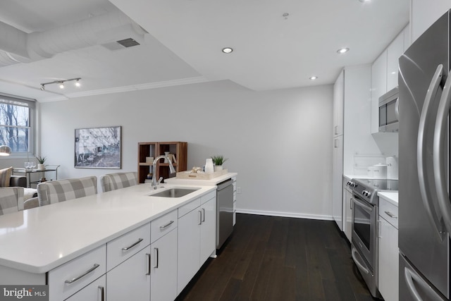 kitchen with appliances with stainless steel finishes, dark hardwood / wood-style flooring, sink, and white cabinets