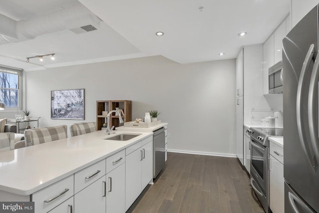 kitchen with appliances with stainless steel finishes, dark hardwood / wood-style floors, sink, and white cabinets