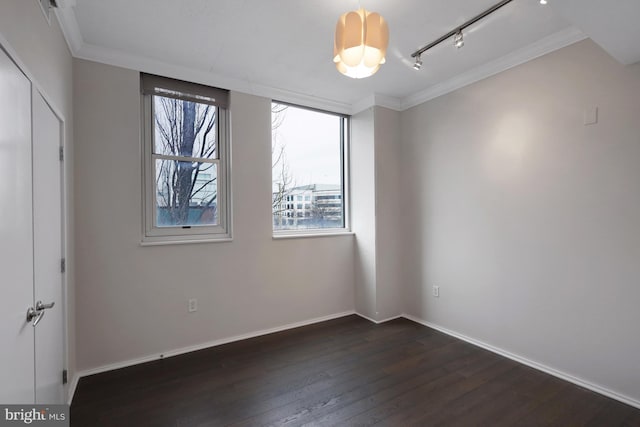 unfurnished room with dark wood-type flooring, ornamental molding, and rail lighting