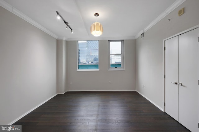 unfurnished room featuring crown molding, track lighting, and dark hardwood / wood-style flooring