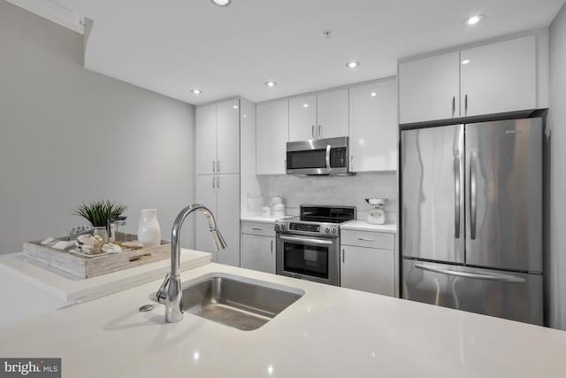 kitchen with tasteful backsplash, white cabinetry, appliances with stainless steel finishes, and sink