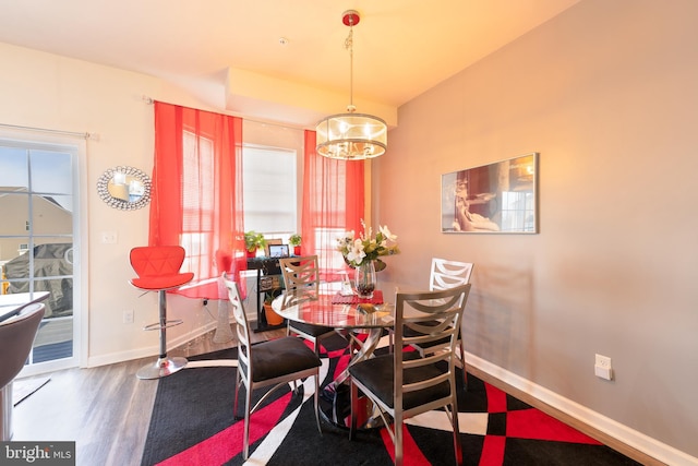 dining space with hardwood / wood-style flooring and a chandelier