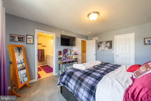 bedroom featuring ensuite bath and light colored carpet