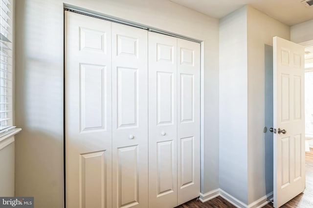 unfurnished bedroom with dark hardwood / wood-style flooring and a closet