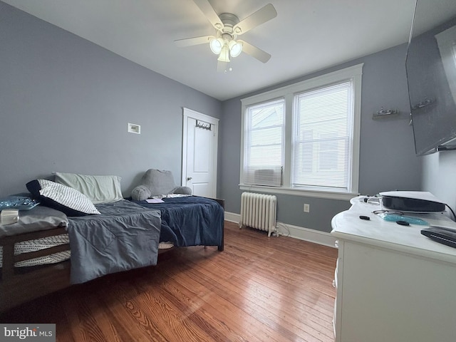 bedroom featuring ceiling fan, radiator, and hardwood / wood-style floors