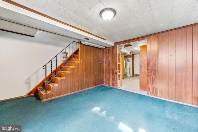 basement with carpet floors, water heater, and wood walls