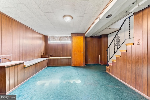 interior space featuring dark carpet and wooden walls