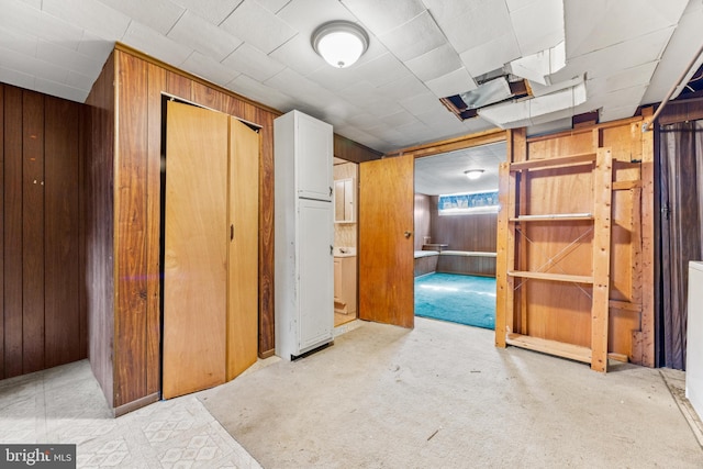 corridor with light colored carpet and wood walls