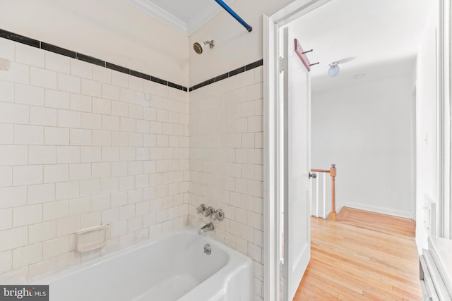 bathroom featuring tiled shower / bath, ornamental molding, and hardwood / wood-style floors