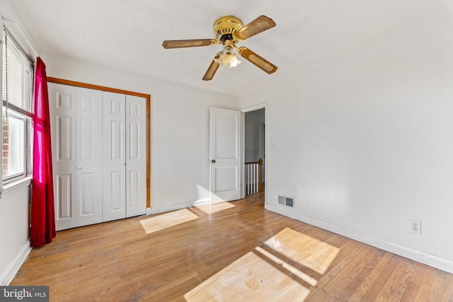 unfurnished bedroom featuring ceiling fan, a closet, and light hardwood / wood-style flooring