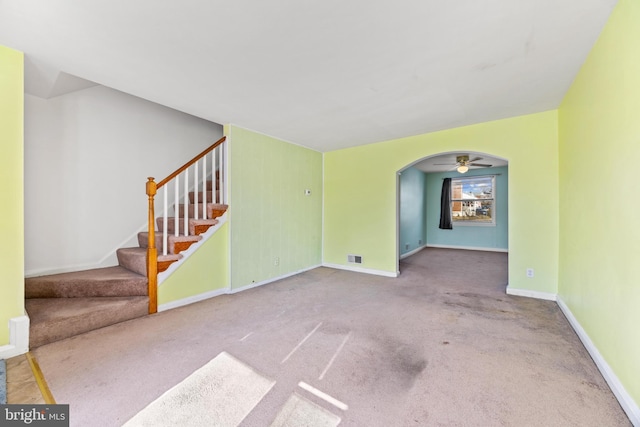 unfurnished living room featuring light colored carpet and ceiling fan