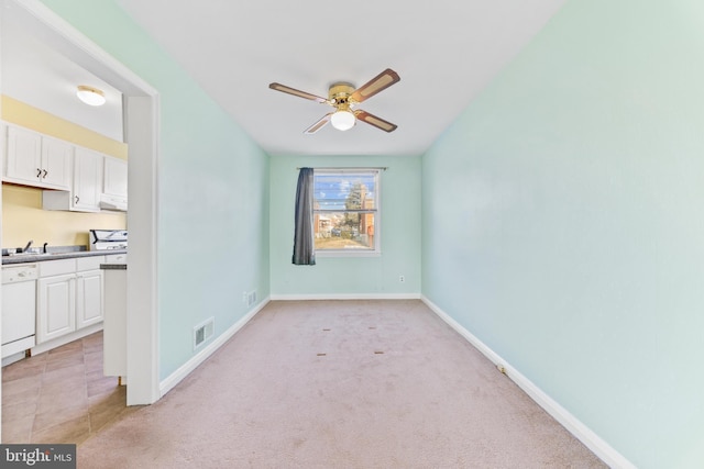 unfurnished dining area with light carpet and ceiling fan