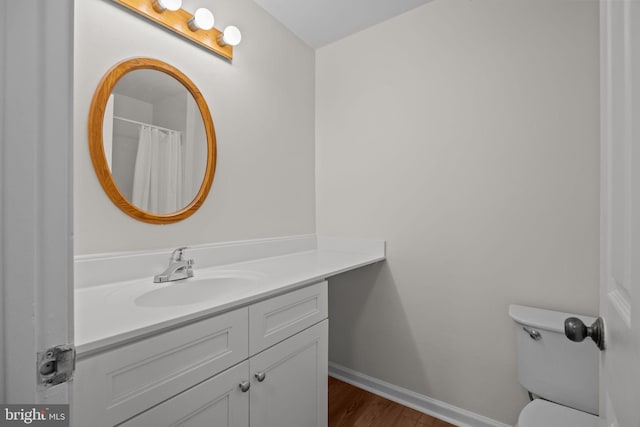 bathroom with vanity, hardwood / wood-style flooring, and toilet