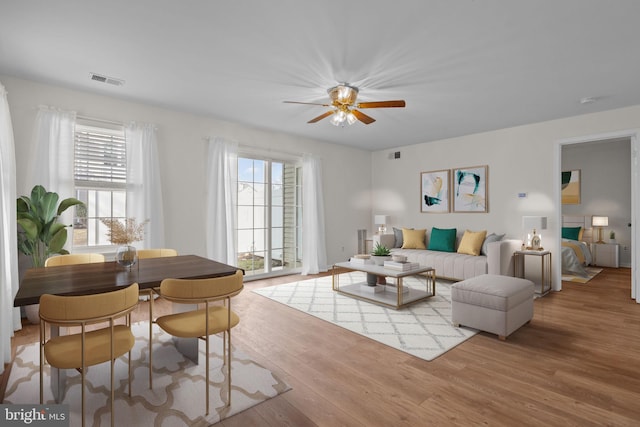 living room with ceiling fan, light hardwood / wood-style flooring, and a wealth of natural light