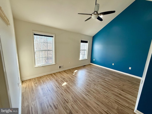 empty room featuring vaulted ceiling, ceiling fan, and light hardwood / wood-style flooring