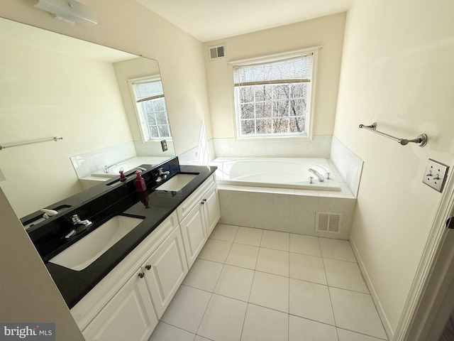 bathroom with vanity, tile patterned flooring, and a relaxing tiled tub