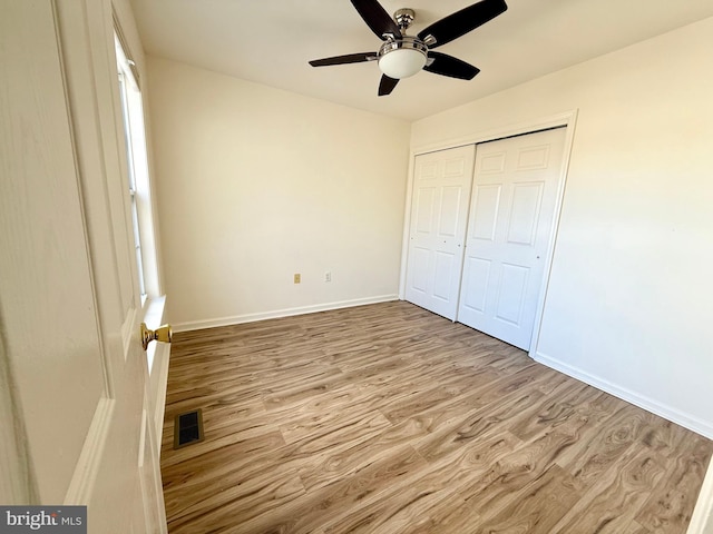 unfurnished bedroom with a closet, ceiling fan, and light wood-type flooring