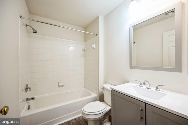 bathroom featuring visible vents, toilet, washtub / shower combination, vanity, and wood finished floors