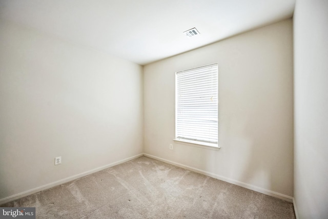 carpeted empty room with baseboards and visible vents