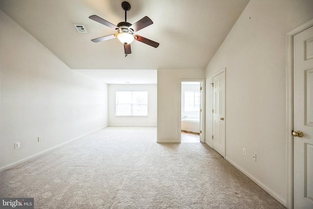 unfurnished bedroom with baseboards, visible vents, ceiling fan, vaulted ceiling, and carpet floors