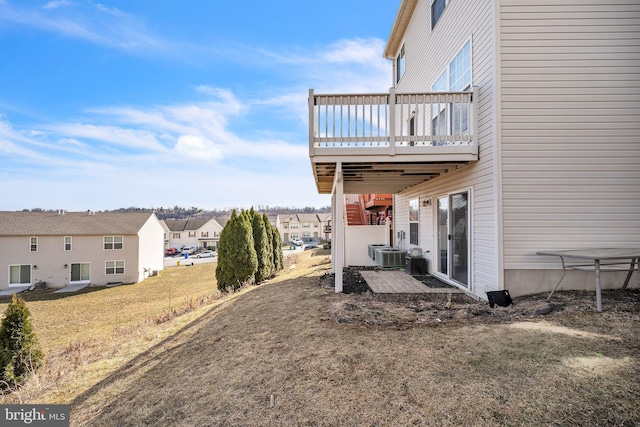 view of yard featuring a residential view, a deck, and central air condition unit