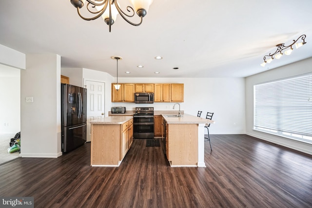 kitchen with dark wood-style flooring, a center island, light countertops, black appliances, and a sink