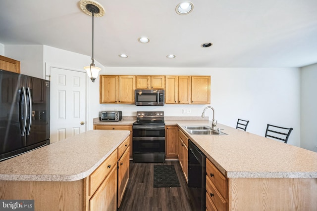 kitchen with stainless steel appliances, a peninsula, a sink, light countertops, and dark wood finished floors