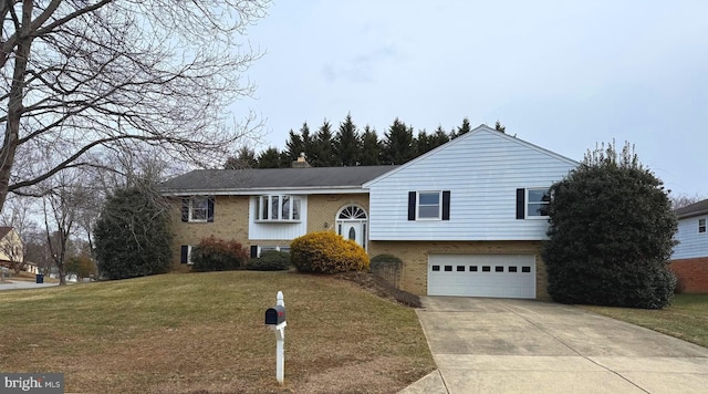 raised ranch featuring an attached garage, brick siding, concrete driveway, and a front yard