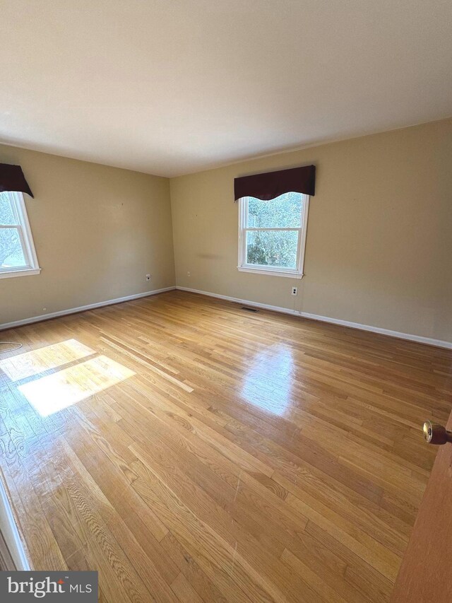 empty room with light wood-style flooring and baseboards